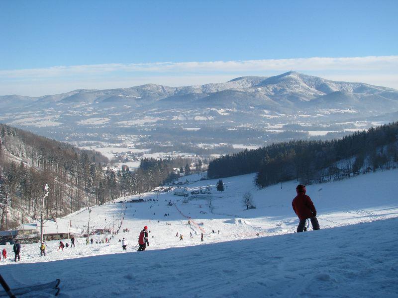Muž na sjezdovce v areálu Opálená rozhlížející se na hory